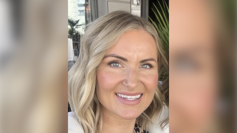 Belinda is looking ahead and smiling. She has a nose ring and shoulder-length blonde hair.