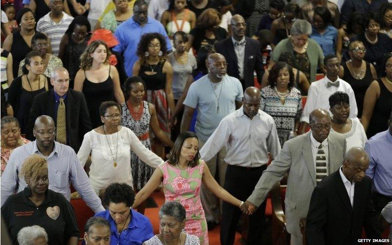 Parishioners embrace as they attend the first church service four days after a mass shooting that claimed the lives of nine people at the historic Emanuel African Methodist Church June 21, 2015 in Charleston, South Carolina