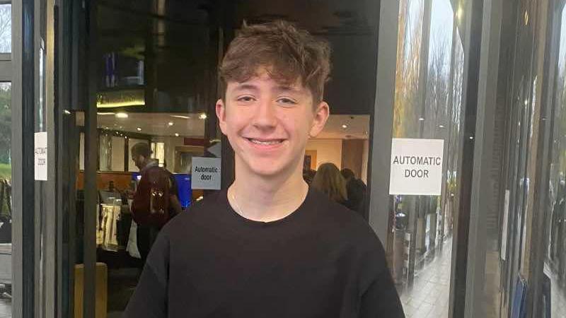 Joshua with brown curly hair and black T-shirt standing outside RTE studios in Dublin