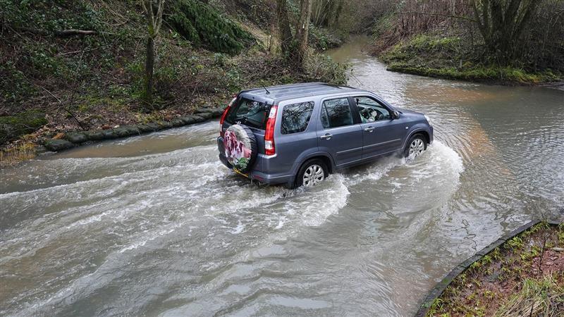 A blue SUV drives through a flooded road in Houndsfield Lane, Birmingham, on Monday.