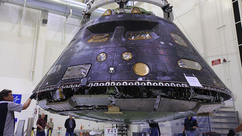 The Orion crew module is pictured - it is the shape of an upturned bowl and has a metallic-looking surface