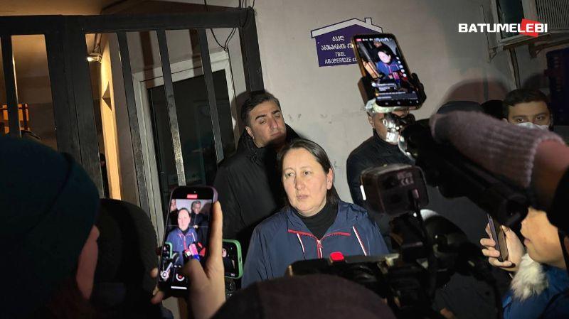 Mzia Amaglobeli stands in front of journalists in Batumi wearing a blue coat with red rims