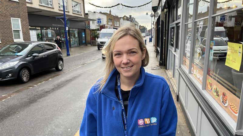 A young woman with blonde hair. She is wearing a blue fleece.