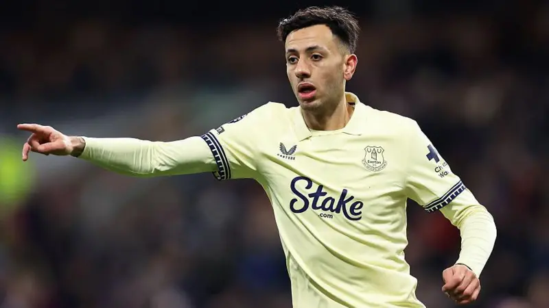 Dwight McNeil. in Everton's yellow away shirt with a yellow undershirt, points with his index finger, with his right arm outstretched