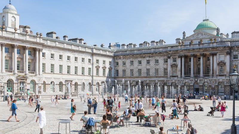 People sitting near fountains in a courtyard by Somerset House in the summer