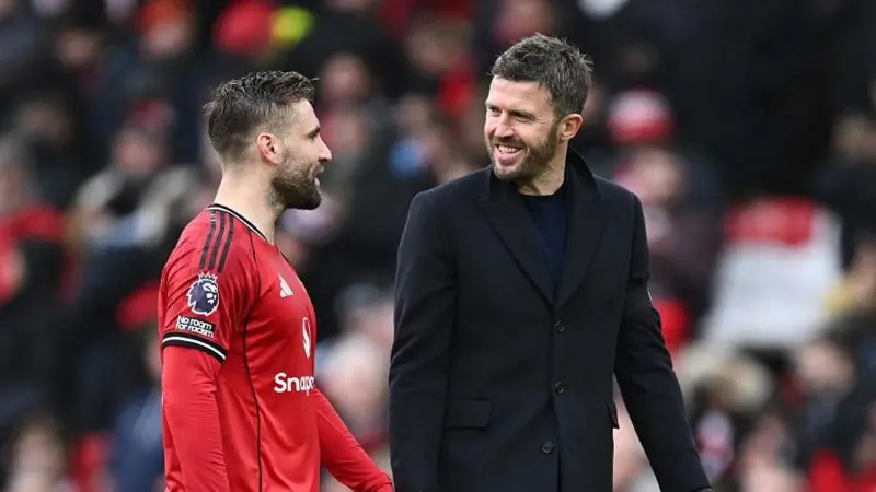 Manchester United head coach Michael Carrick (right) shares a joke with defender Luke Shaw