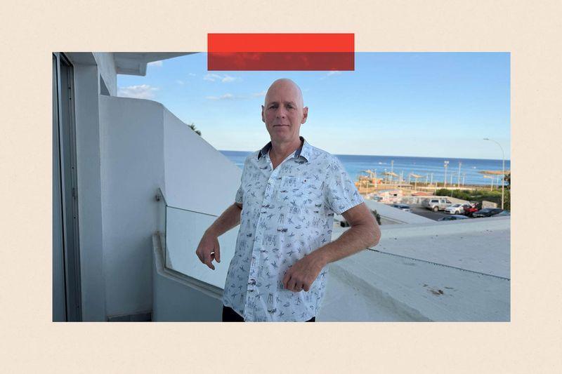 Michael Carpenter wears a shirt and stands with a view in the background