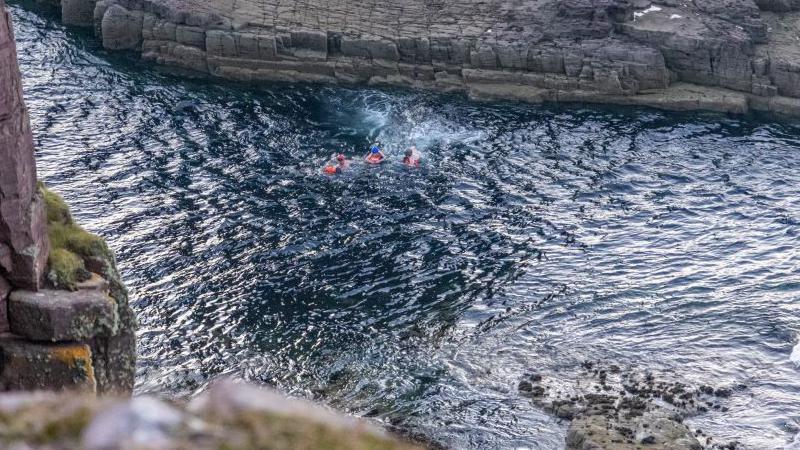 Aden, his dad and climbing instructor Jim make the swim back from sea stack Am Buachaille