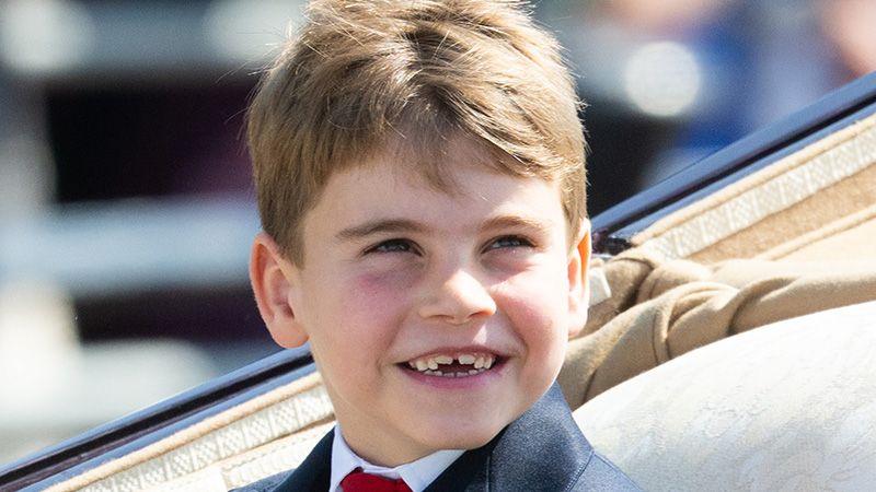 Prince Louis smiles showing his new front teeth coming through as he sits in a carriage
