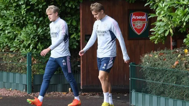 Matt Smith walks out at Arsenal's training ground with Martin Odegaard in 2022