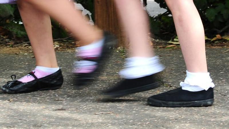 Two pairs of children's feet walking