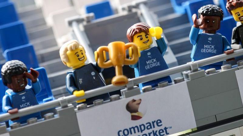 Lego Peterborough United players holding a trophy aloft in the replica stand