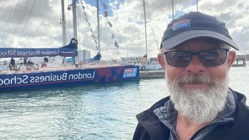 Bob Brown smiling at the camera with his team's boat in the background.