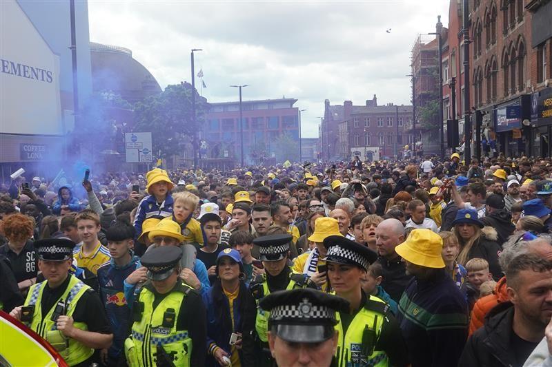 A crowd of fans with police officers at the front 