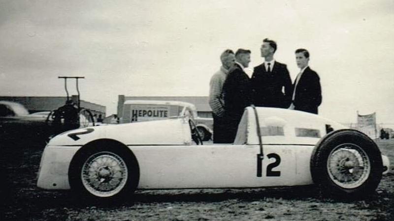 A black and white photograph of four men standing behind the RA4 Vanguard