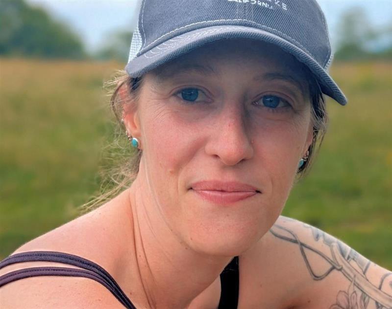 Kelsey Lahr wears a baseball cap in a field near her home in Asheville, North Carolina