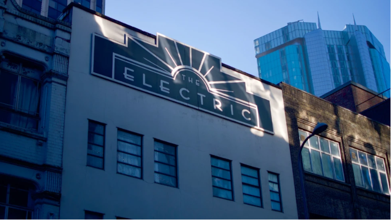 A close up of the Electric cinema. It is a white building with a black and white sign that says "The Electric" in thin font.