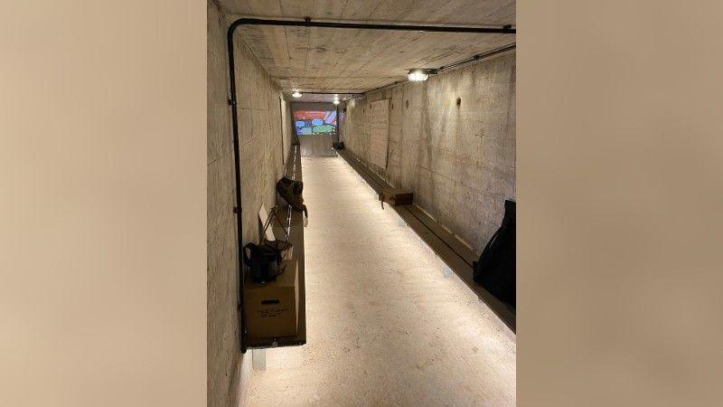 An image inside the bunker. It is a narrow and long room which is grey in colour with some 1940s props inside.