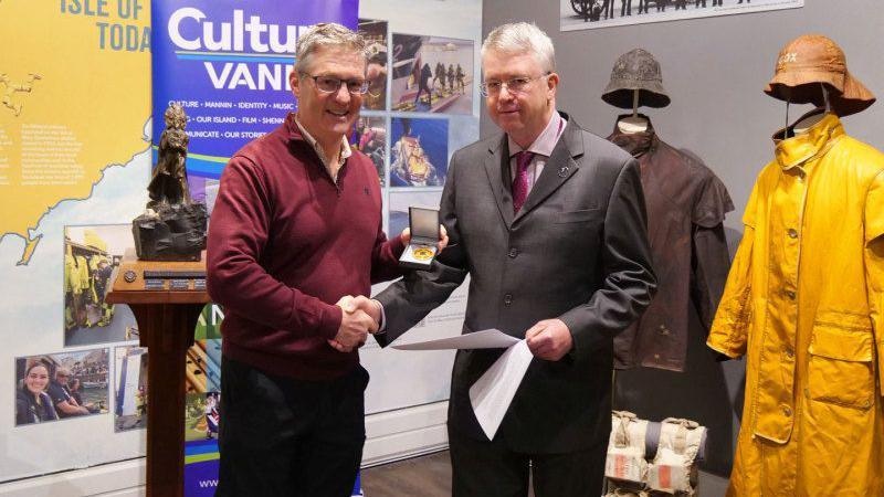 Adrian Corkill being presented with the award by Jonathan Hall of Manx National Heritage