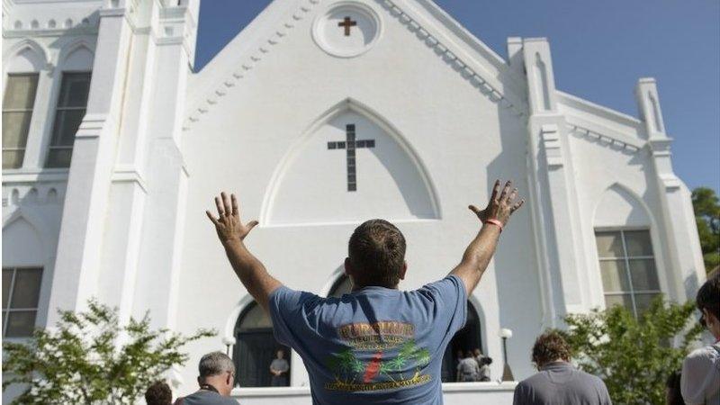 People listen to the Sunday service outside the Emanuel AME Church June 21, 2015 in Charleston, South Carolina