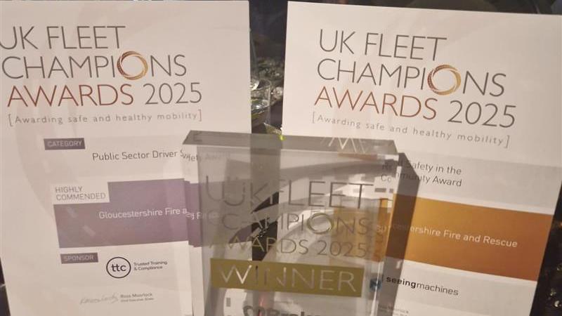 An award with the words "winner" on it, standing in front of two certificates which read "UK Fleet Champions Awards 2025"