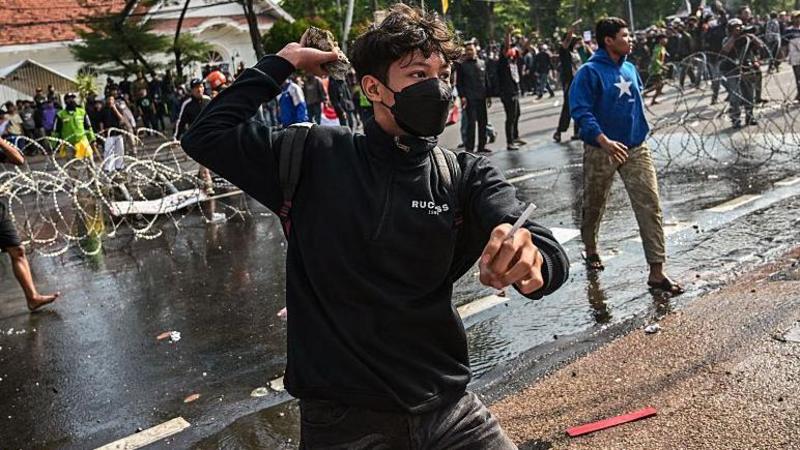 Protesters and police clash after death of taxi driver in Indonesia