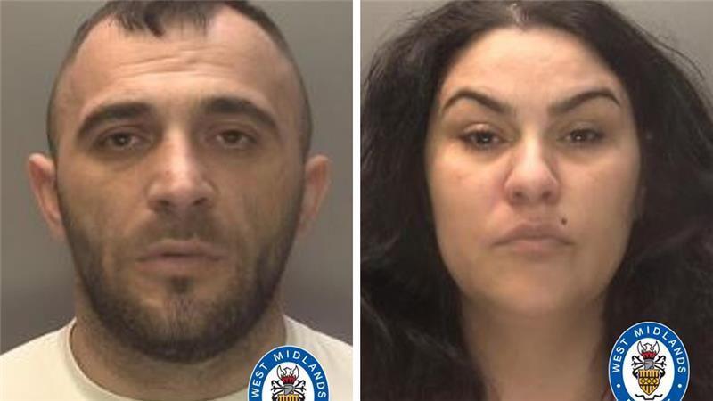 A composite of two mugshots side by side. On the left is a man with very short dark hair and a stubbly beard. He is wearing a white shirts. On the right is a woman with long, thick black hair and a mole over her lip.