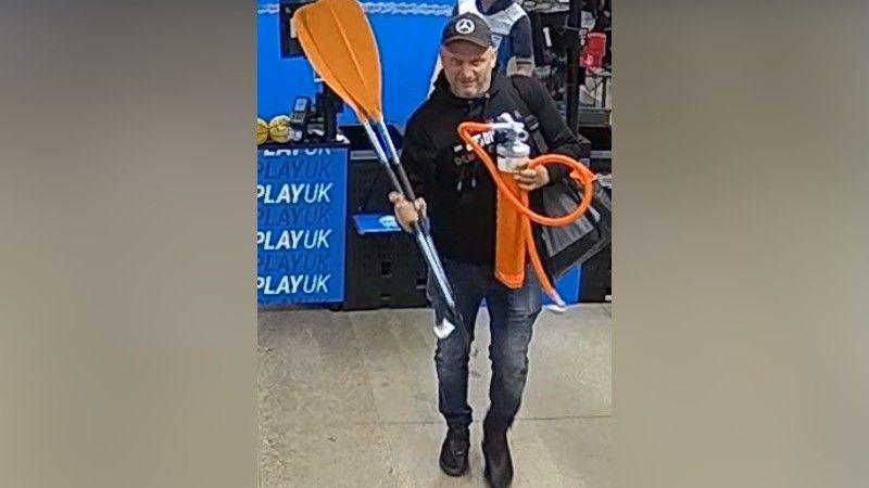 CCTV image of Arsen Feci with a pair of orange oars and a orange pump inside a Decathlon store