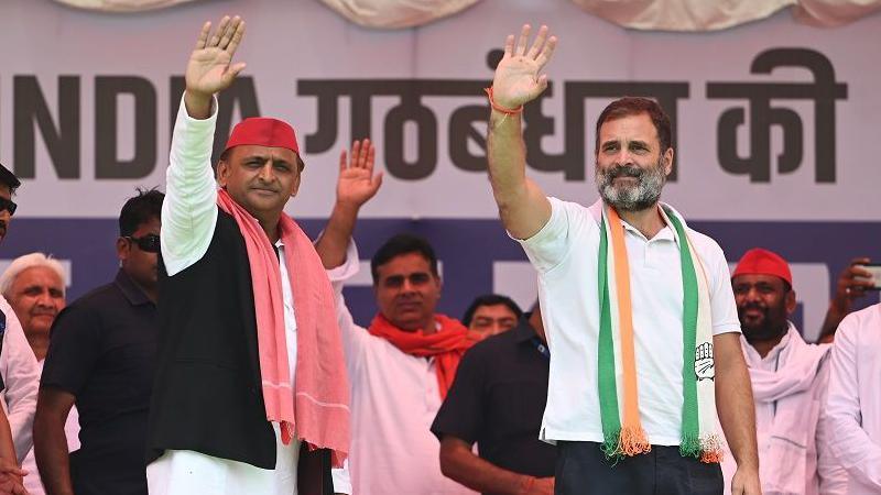 Akhilesh Yadav (left) and Rahul Gandhi wave at an election rally in UP