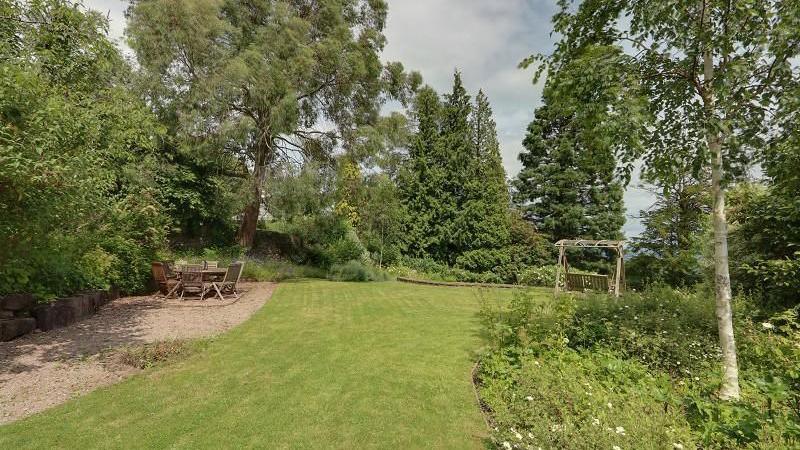 A large garden with lawn, trees and shrubery