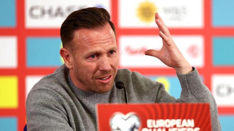 Craig Bellamy raises a hand during his post-match press conference
