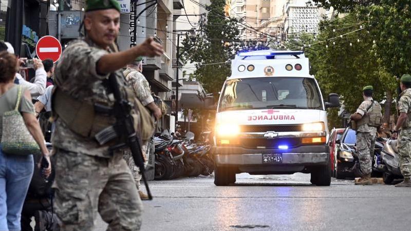 ambulance heads towards hospital in Lebanon as soldier looks on