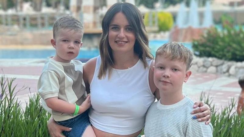 Lauren, a woman in her 30s, pictured on holiday with her two child