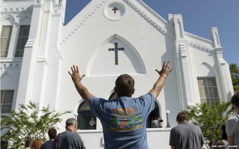 People listen to the Sunday service outside the Emanuel AME Church June 21, 2015 in Charleston, South Carolina