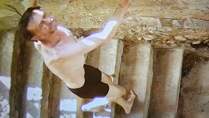 A surveillance photo shared by police with the public, in which the suspect, Michael Brown, is seen shirtless, barefoot and wearing only black shorts, and walking down a set of stairs while leaning against a stone wall.

