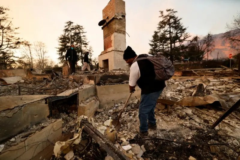 A man searches through rubble after the fires destroyed a building in the Los Angeles area.