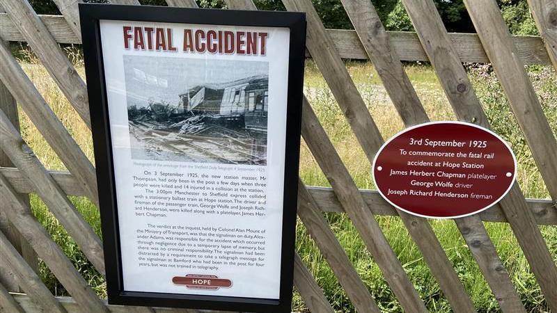 The plaque and information panel on fencing at the edge of the platform