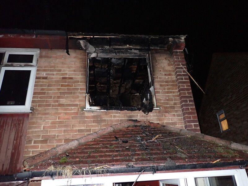 A close up image of a blown out window, now a black smoky hole, on the first floor of the property