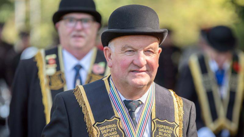A man with a bowler hat takes part in a parade in Killyleagh, County Down