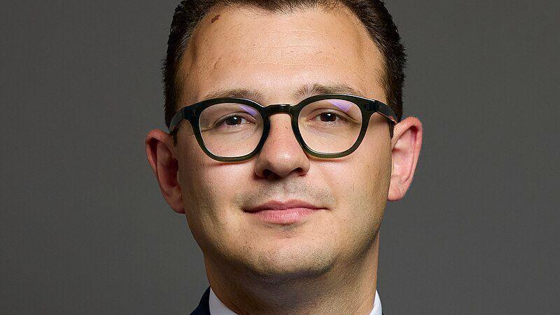 A parliamentary headshot of Jack Rankin, a man with short dark hair and wearing thick-rimmed black glasses, looking straight at the camera.