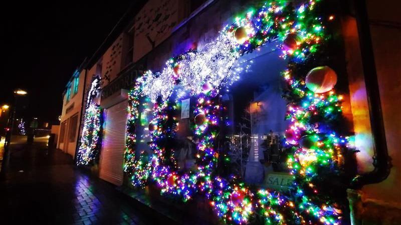 Christmas lights attached to the outside of a shop