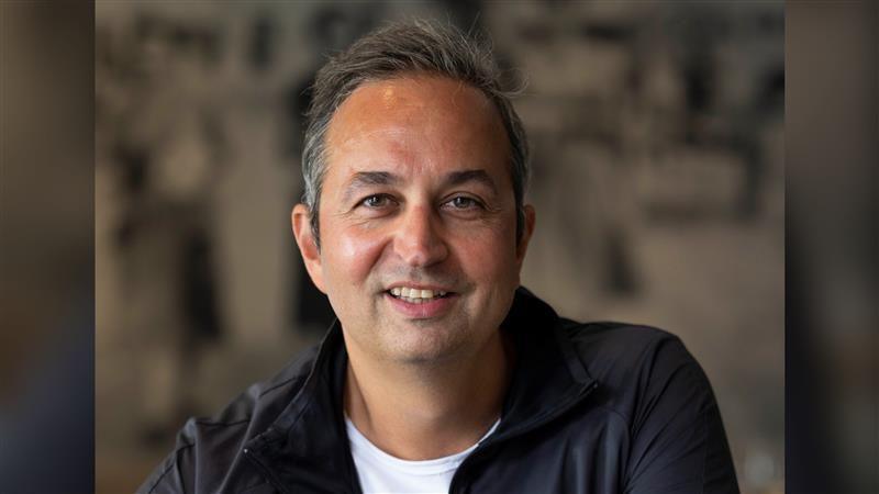 A man with grey hair looking and smile at the camera.