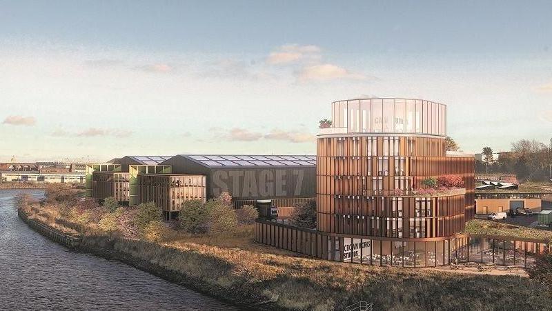 A CGI of how Crown Works Studios could look once built. A large glass building stands overlooking the River Wear. Next to it are large warehouse-like structures. The nearest one has Studio 7 painted across one of its outer walls.