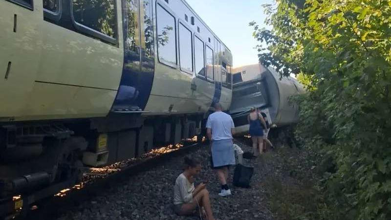 People sat next to the side of the track after the derailment having escaped the carriage