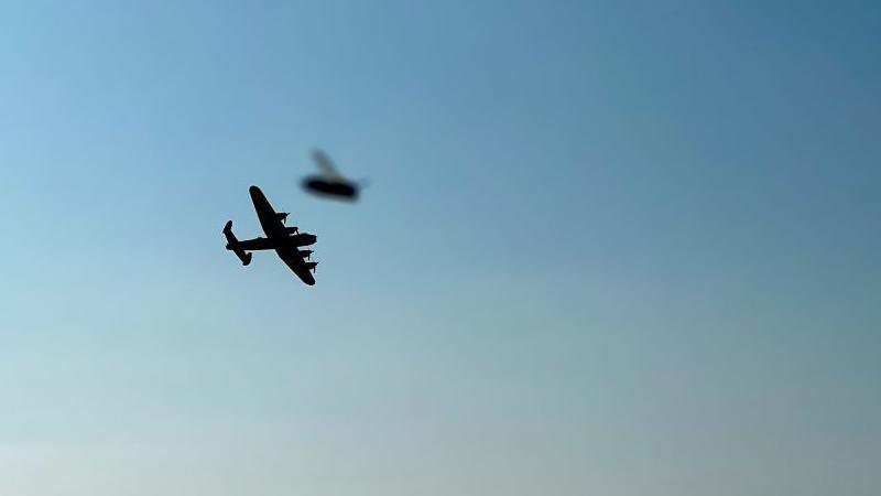 A World War Two Lancaster aircraft in flight with a bee 