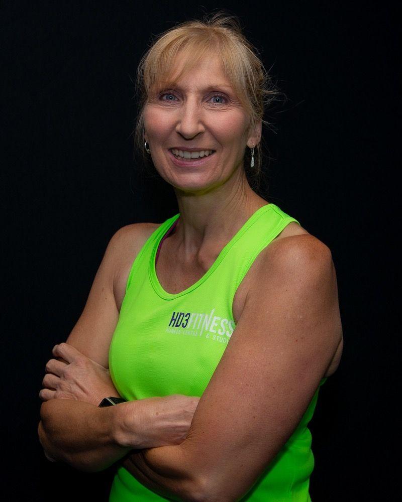 Ruth Dawson wears a green tank top and poses with her arms crossed 