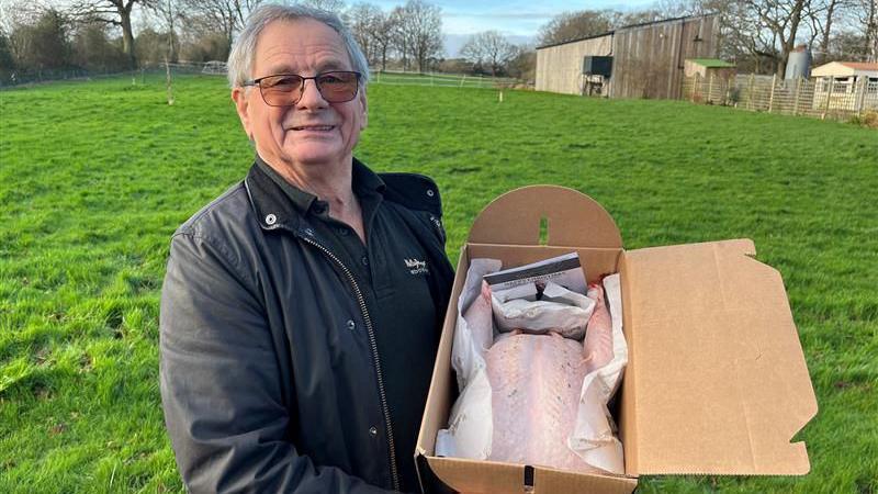 Tony Fleck from Kent Turkeys holds a prepared turkey in a box on his land at Woolpack Corner Farm in Biddenden