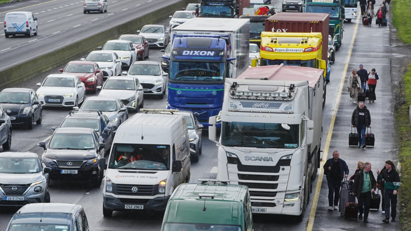 People walk along motorway towards Dublin Airport as fuel protests continue