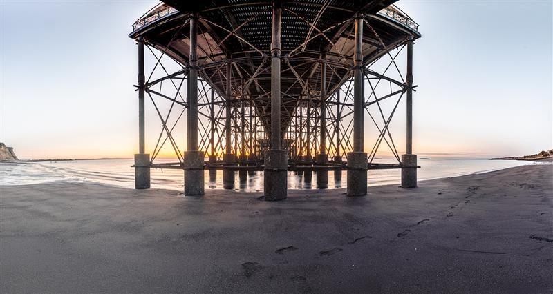 Underneath Penarth pier - the base of the structure surrounded by sand and sea