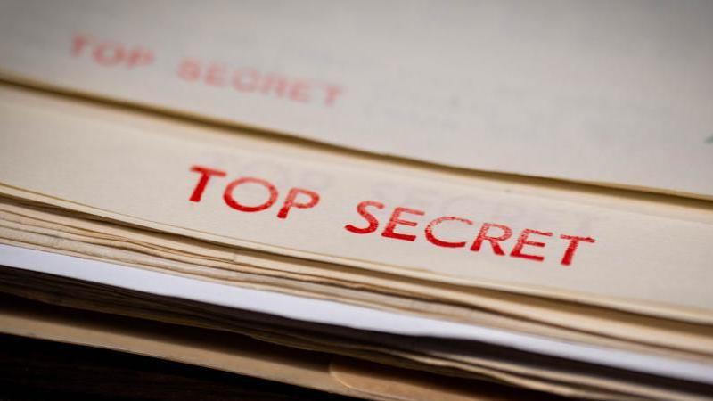 A file is shown with the words 'Top secret' in red letters across the top.